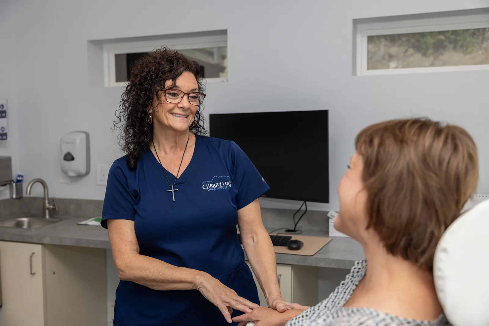 Team member reassuring a relaxed patient in the treatment chair
