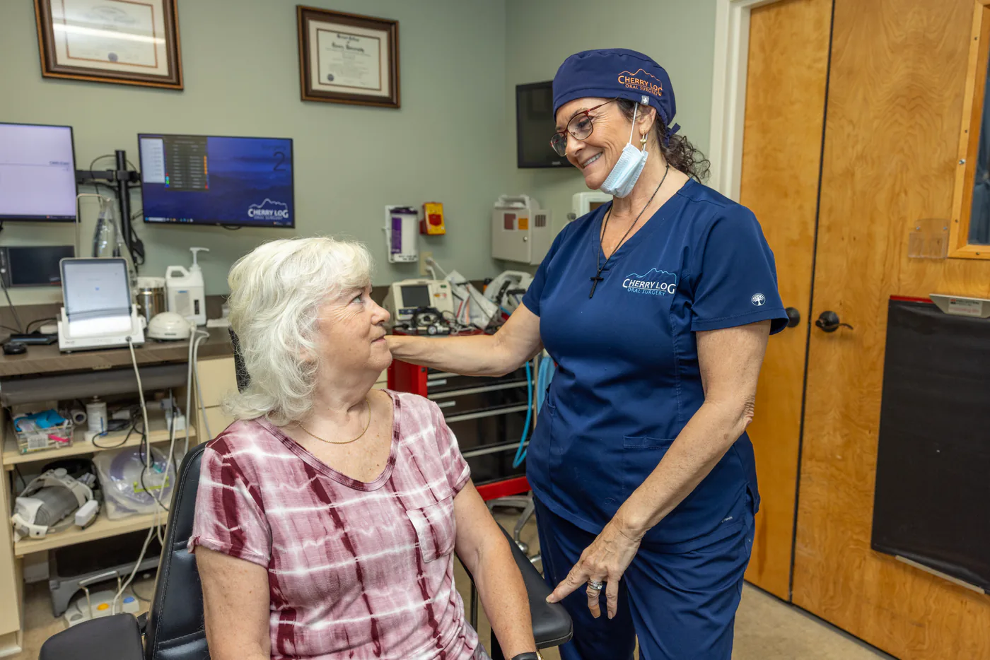 Surgical assistant comforting a patient in the treatment chair
